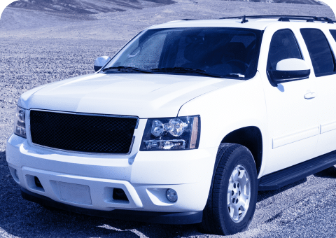 A white SUV from Promex Auto is parked on a barren, rocky terrain. The vehicle's front and side are visible, showcasing its robust build and tinted windows. The landscape is dry and mountainous in the background, hinting at the rugged adventures made possible by top-notch auto repair services.