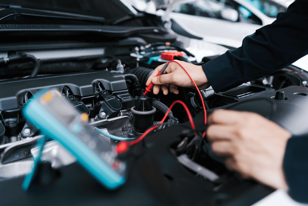 auto electrical repair, auto repair in Newport, NH at Promex Auto. Image of a technician using a multimeter to inspect a vehicle’s electrical system.