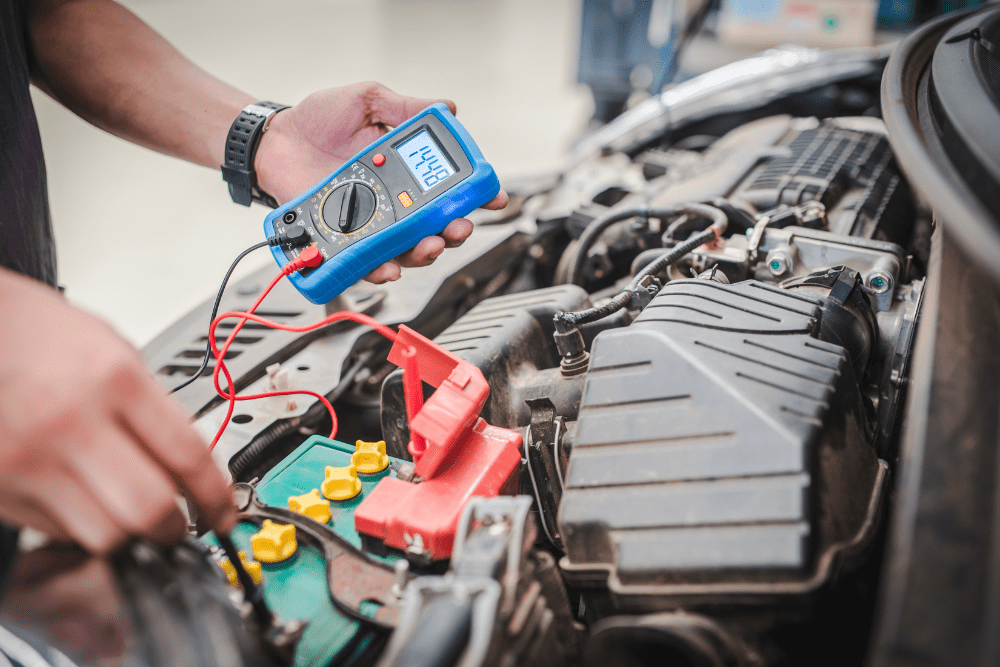 electrical diagnostics in Newport, auto repair in Newport, NH at Promex Auto. An automotive technician uses a digital multimeter to test the voltage of a car battery.