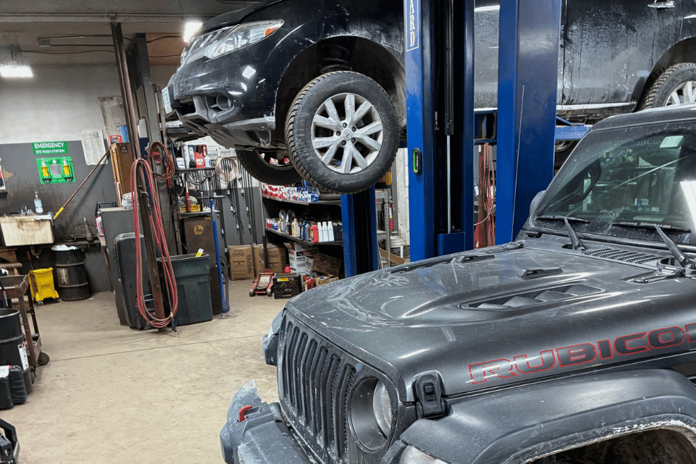 Auto Repair in Grantham NH At Promex Auto and Tire. Jeep Rubicon and SUV raised on lifts inside auto repair shop.