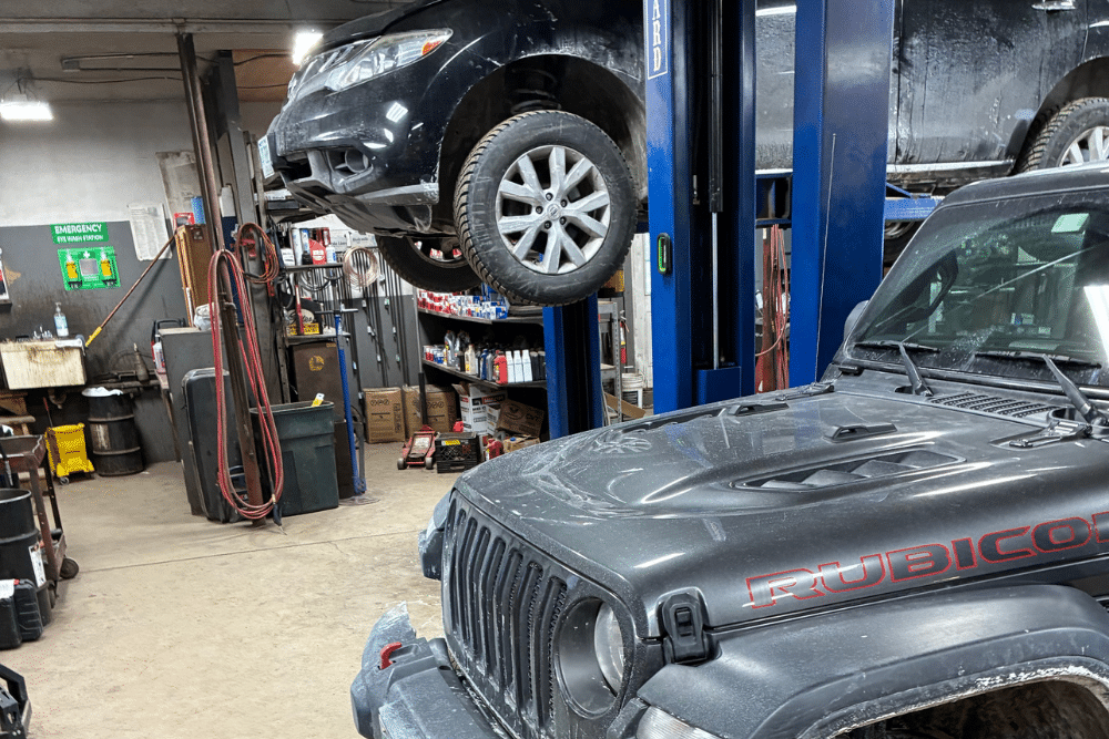 Auto Repair in Grantham NH At Promex Auto and Tire. Jeep Rubicon and SUV raised on lifts inside auto repair shop.